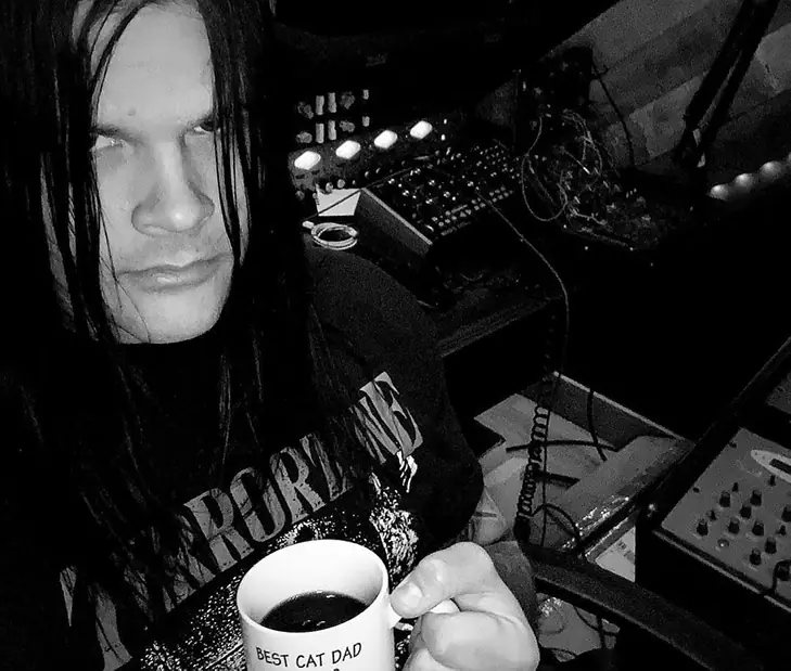 Travis Bacon in a Studio drinking coffee.
